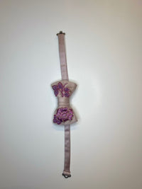 Blush pink silk bow tie with purple and lilac floral Sermeh embroidery on the knot, shown flat against a plain white background.
